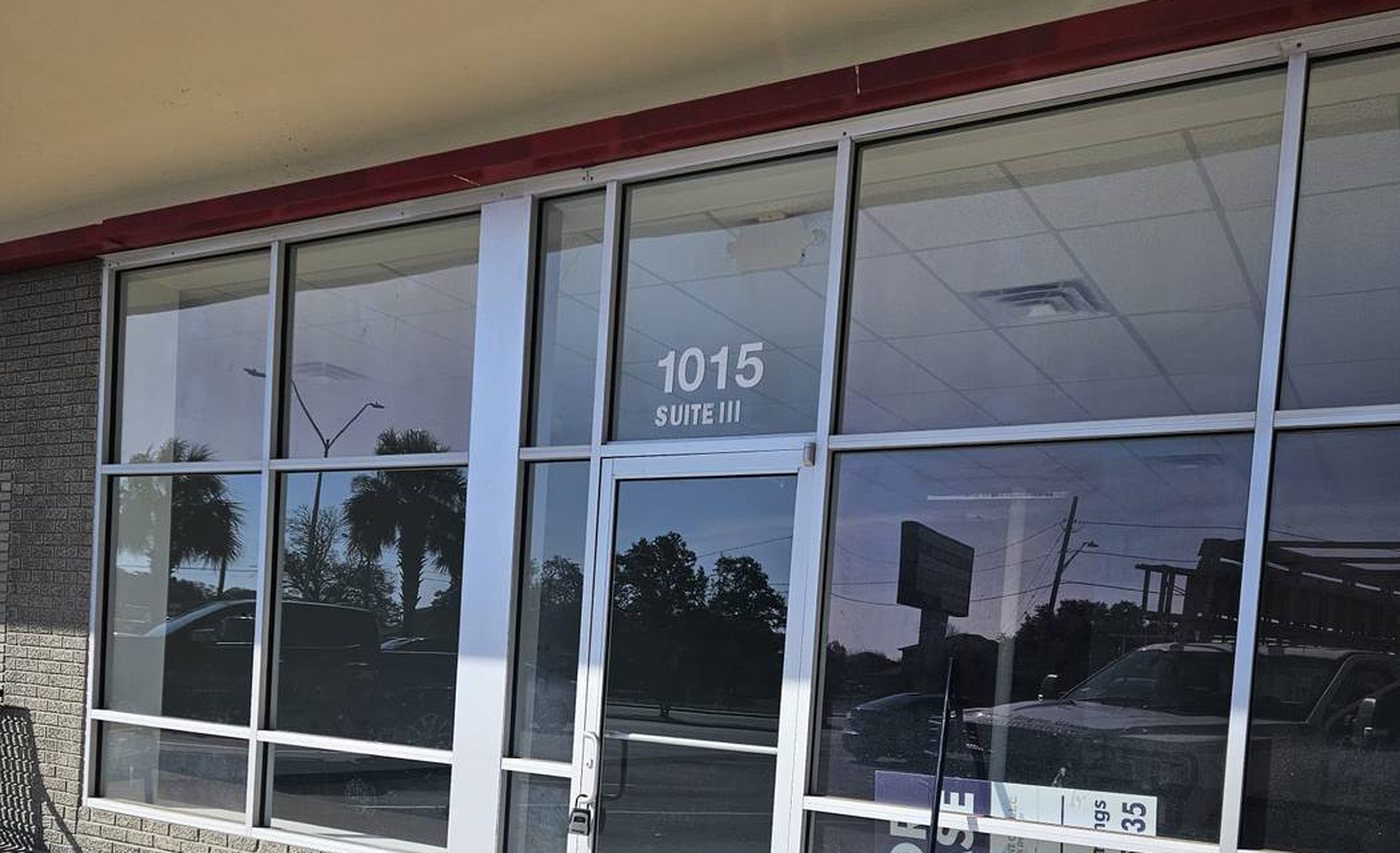 Aluminum storefront with glazed entrance door, transom and fixed lights on a retail unit in San Antonio
